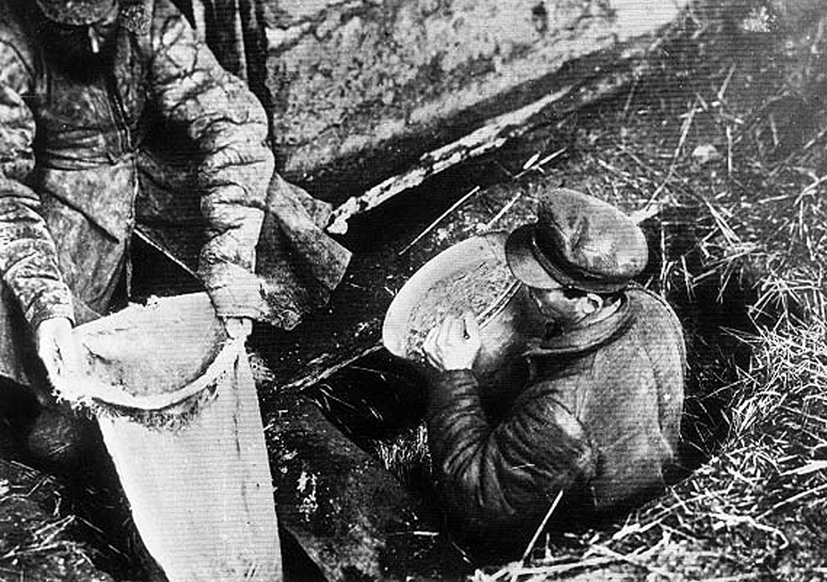 Des responsables soviétiques confisquent des céréales à une famille paysanne en Ukraine. En 1932-1933, l’Holodomor fut une famine provoquée par Staline ©akg-images/Pictures From History 